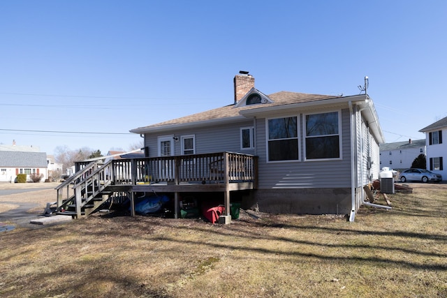 back of house with a deck, stairs, a lawn, and a chimney