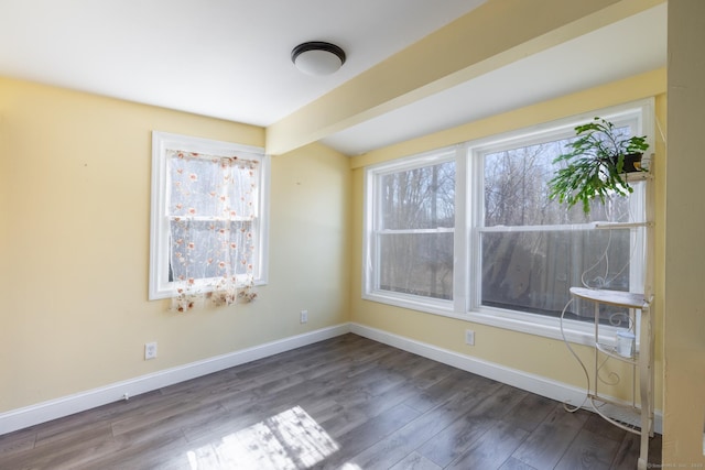 unfurnished room featuring baseboards and wood finished floors