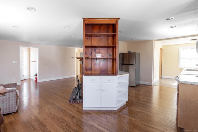 kitchen featuring open shelves, open floor plan, wood finished floors, white cabinetry, and freestanding refrigerator