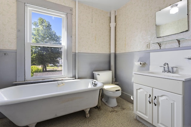 full bath featuring wainscoting, toilet, and wallpapered walls