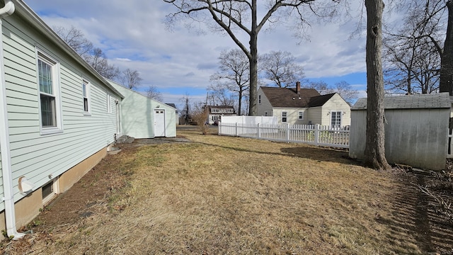 view of yard featuring an outdoor structure and fence