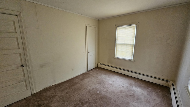 carpeted spare room with crown molding and baseboard heating