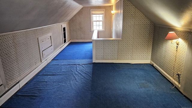 additional living space with wallpapered walls, lofted ceiling, carpet, and a baseboard radiator