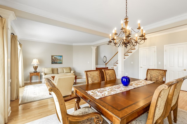 dining space featuring baseboards, stairs, light wood-type flooring, decorative columns, and crown molding