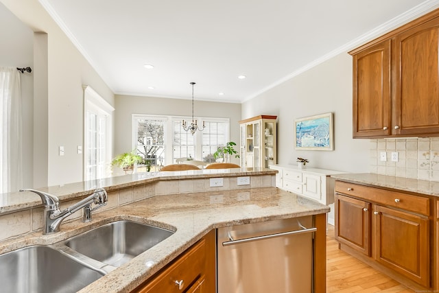 kitchen featuring decorative backsplash, brown cabinets, a sink, and ornamental molding