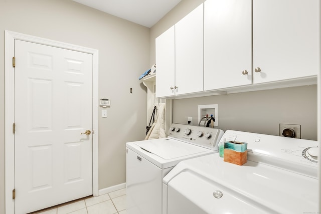 washroom featuring baseboards, cabinet space, washing machine and clothes dryer, and light tile patterned flooring