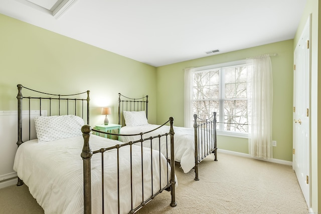 bedroom featuring baseboards, visible vents, and light colored carpet