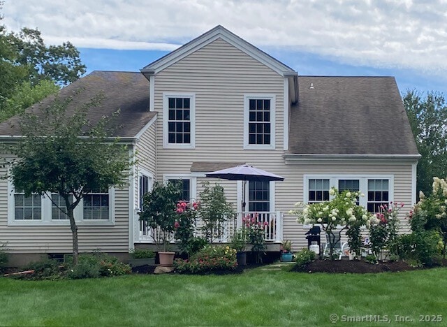 rear view of house featuring a lawn