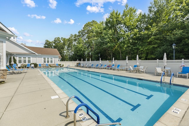 pool with a patio and fence