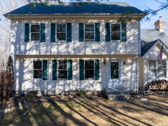 colonial-style house with a chimney and a shingled roof