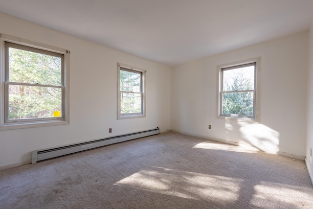 empty room featuring a wealth of natural light, baseboard heating, and carpet floors