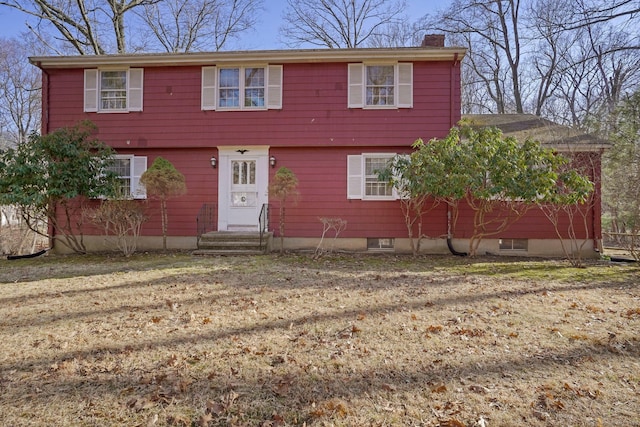 colonial inspired home featuring entry steps and a chimney