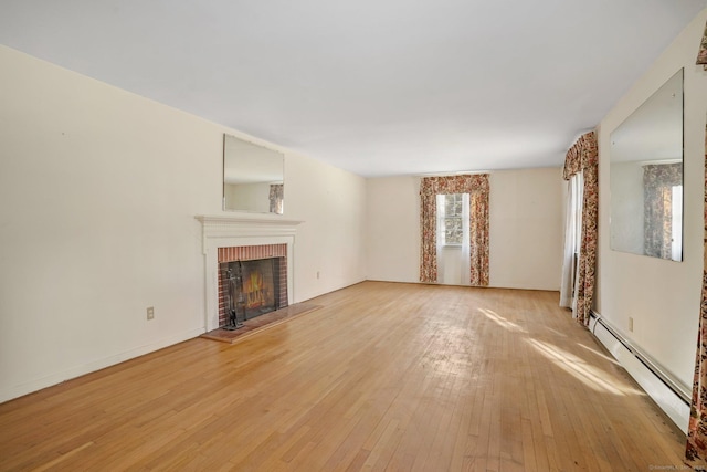 unfurnished living room featuring a brick fireplace, light wood-style floors, and a baseboard radiator