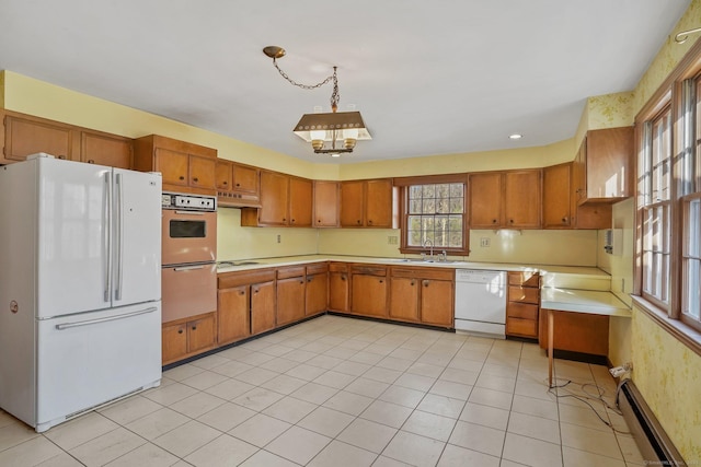 kitchen with brown cabinets, a sink, a baseboard heating unit, white appliances, and light countertops