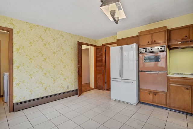 kitchen with wallpapered walls, under cabinet range hood, freestanding refrigerator, and a baseboard radiator