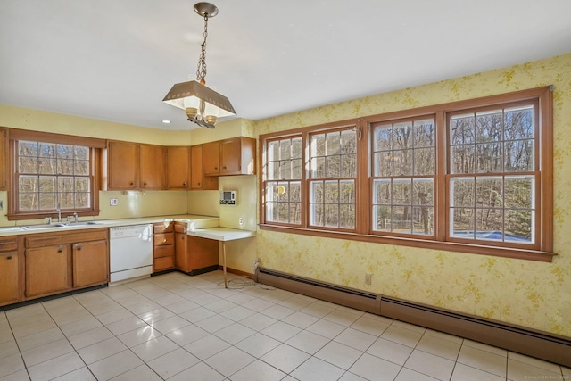 kitchen with a sink, wallpapered walls, white dishwasher, light countertops, and baseboard heating