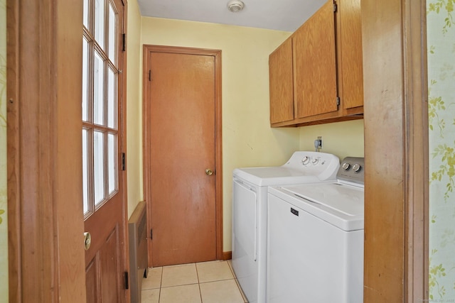 laundry room featuring light tile patterned floors, cabinet space, and washing machine and dryer