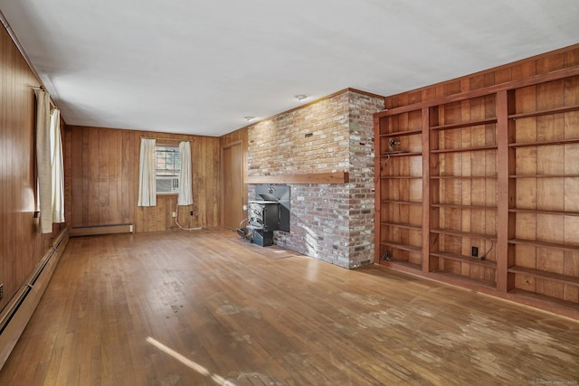 unfurnished living room featuring a baseboard heating unit, hardwood / wood-style flooring, a wood stove, and wooden walls