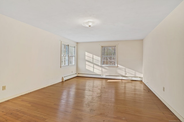 empty room featuring a baseboard radiator and wood finished floors