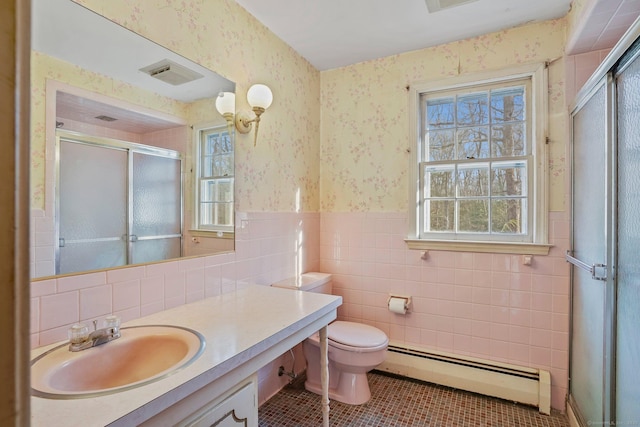 bathroom featuring a baseboard radiator, wallpapered walls, a shower stall, wainscoting, and a wealth of natural light