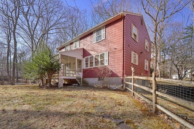 exterior space featuring fence and a sunroom