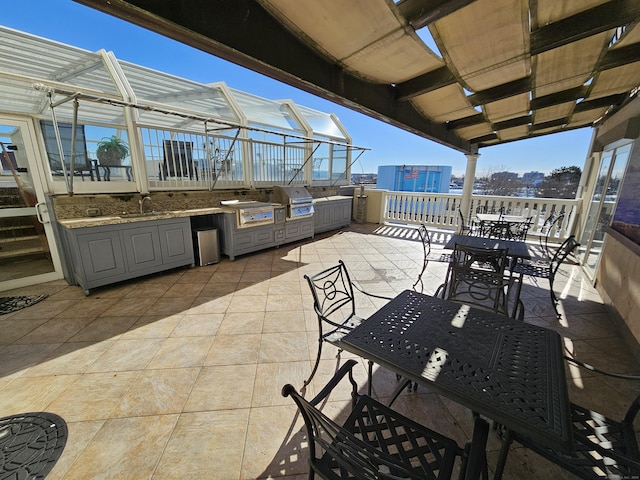 view of patio / terrace with an outdoor kitchen, a grill, outdoor dining area, and a sink