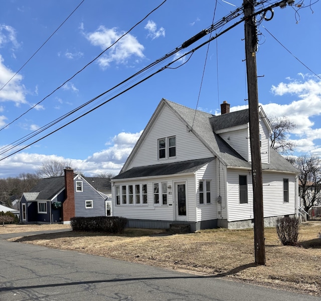 view of front of home with roof with shingles and a chimney