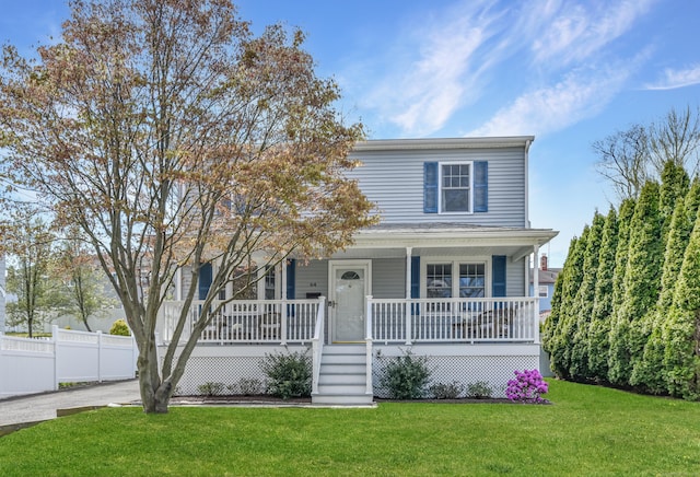 view of front of home with a porch, fence, a front yard, and driveway