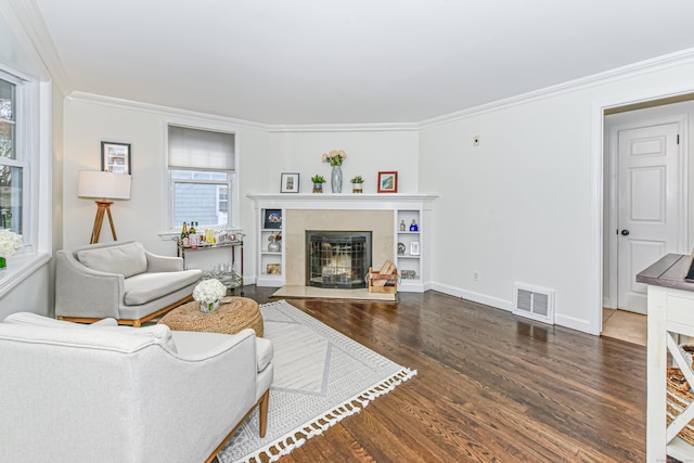 living area with a premium fireplace, wood finished floors, visible vents, and ornamental molding