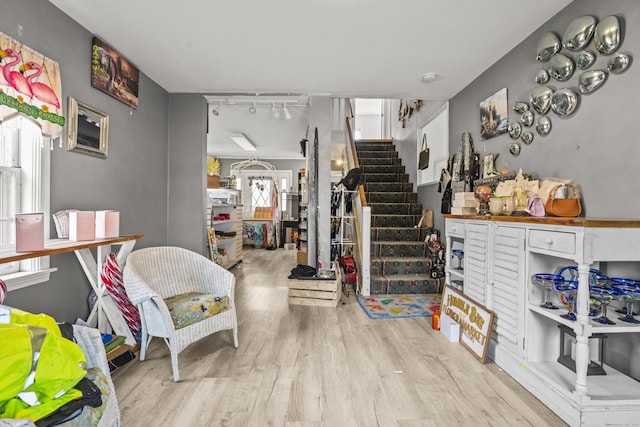 interior space featuring track lighting, wood finished floors, and stairs