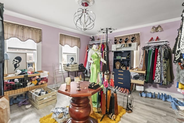 interior space featuring wood finished floors, an inviting chandelier, and ornamental molding