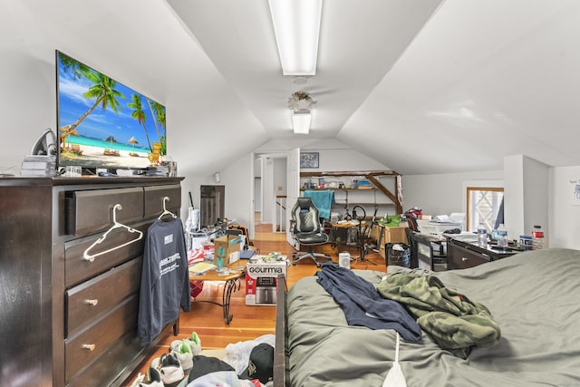 bedroom with vaulted ceiling and wood finished floors