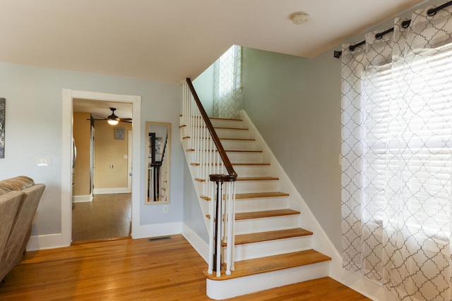 staircase with visible vents, baseboards, and wood finished floors