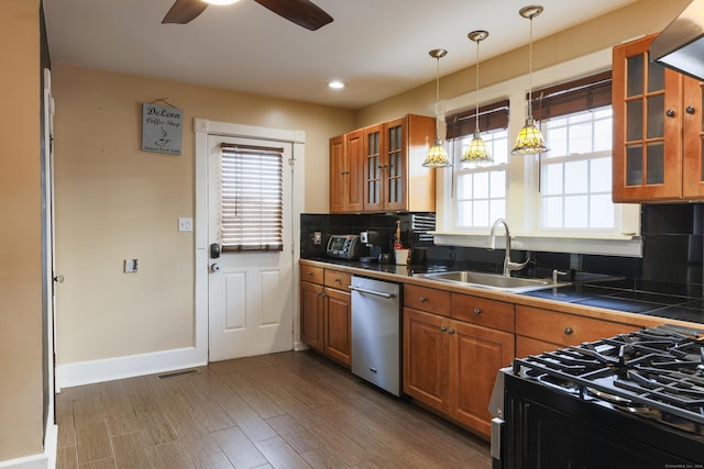 kitchen with decorative backsplash, brown cabinets, appliances with stainless steel finishes, and a sink