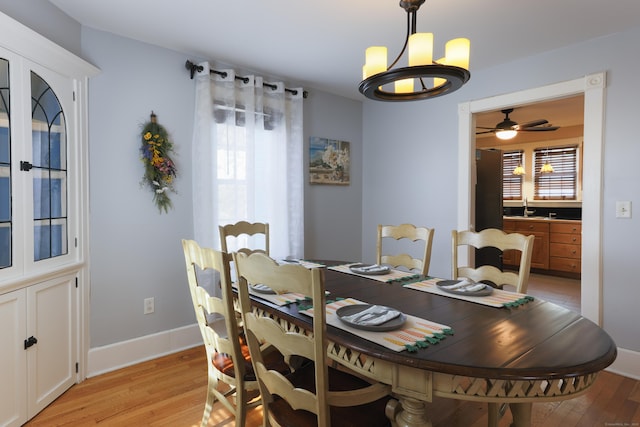 dining area featuring light wood-type flooring, a notable chandelier, and a healthy amount of sunlight