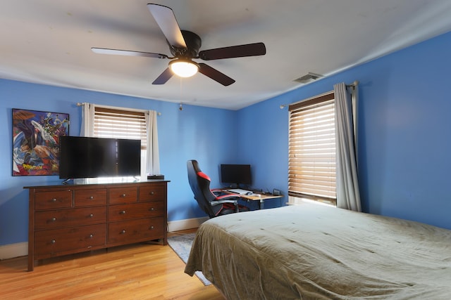 bedroom featuring a ceiling fan, baseboards, visible vents, and light wood finished floors