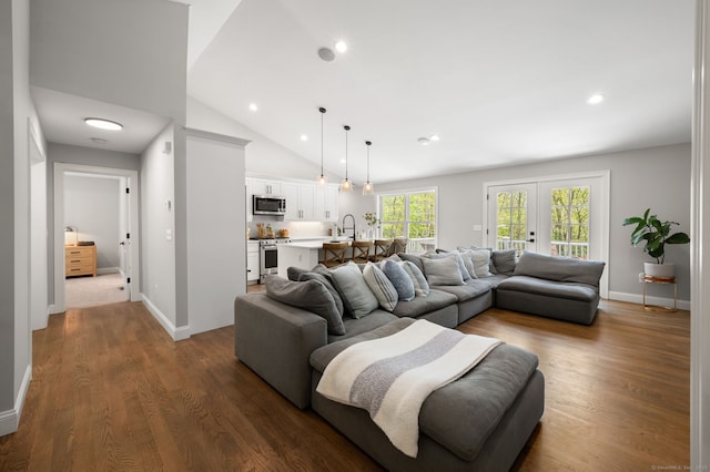 living area with baseboards, dark wood finished floors, recessed lighting, french doors, and high vaulted ceiling