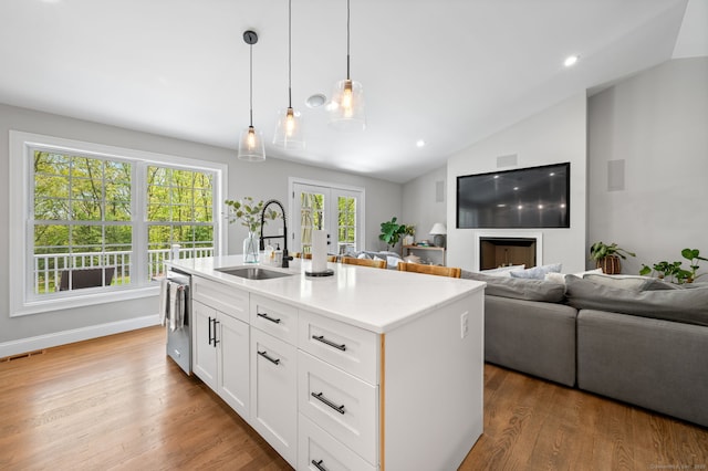 kitchen featuring visible vents, dishwasher, french doors, wood finished floors, and a sink