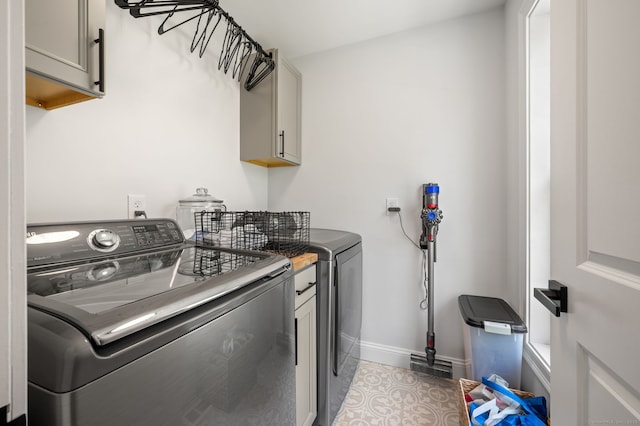 laundry area with washing machine and clothes dryer, visible vents, cabinet space, and baseboards