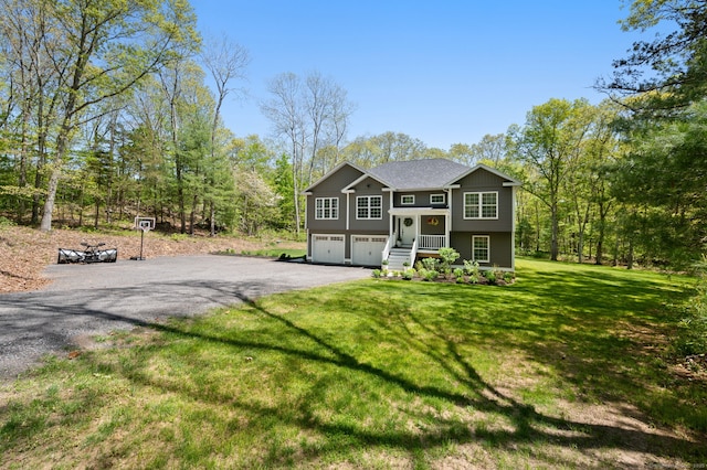 split foyer home with a front lawn, an attached garage, and driveway