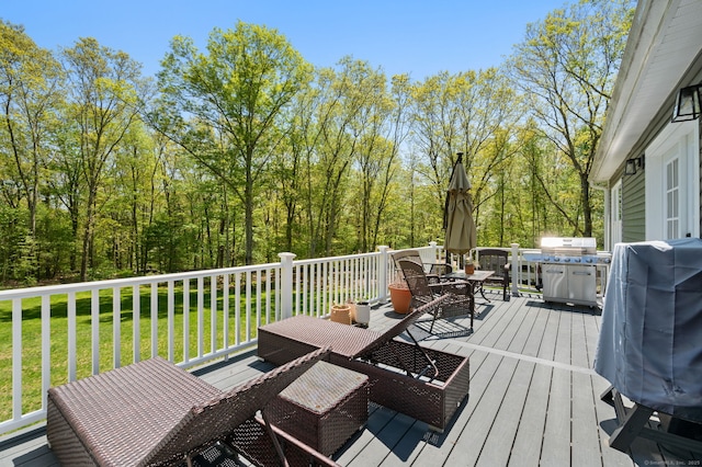 wooden deck with a lawn, a grill, and outdoor dining area