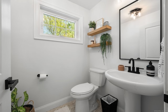 half bathroom featuring toilet and baseboards