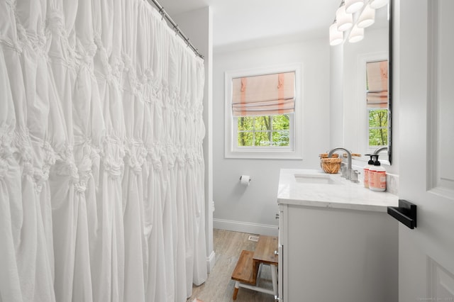 full bath featuring baseboards, wood finished floors, and vanity