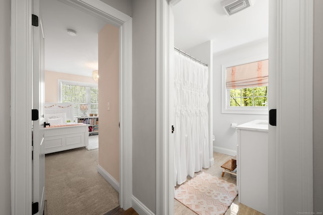 full bath with vanity, baseboards, visible vents, and a wealth of natural light