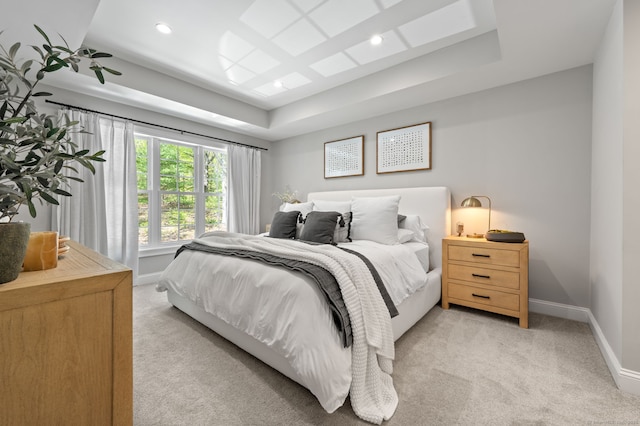 bedroom featuring a raised ceiling, recessed lighting, light colored carpet, and baseboards