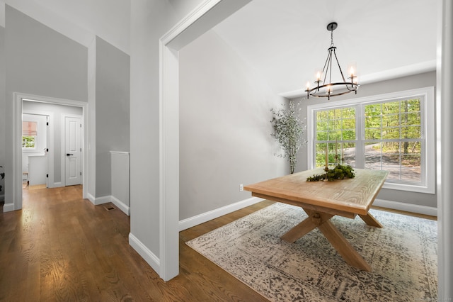 dining room featuring baseboards, an inviting chandelier, and wood finished floors