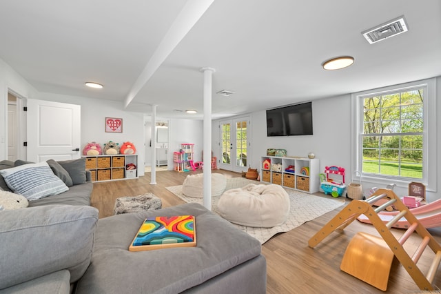 recreation room with visible vents, french doors, and wood finished floors