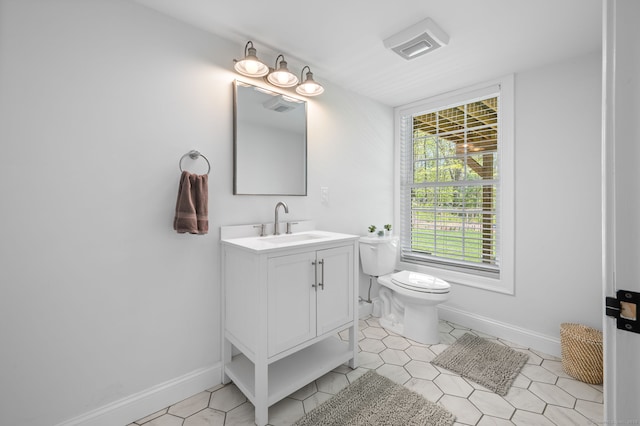 bathroom with vanity, toilet, baseboards, and tile patterned flooring