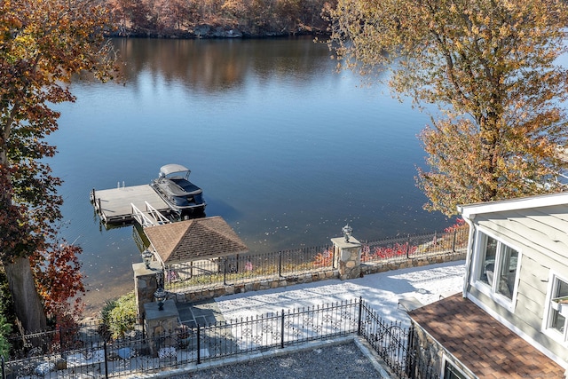 dock area with a water view and fence