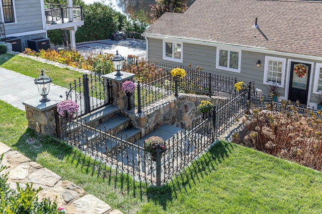 view of home's exterior with a shingled roof, central AC unit, and fence